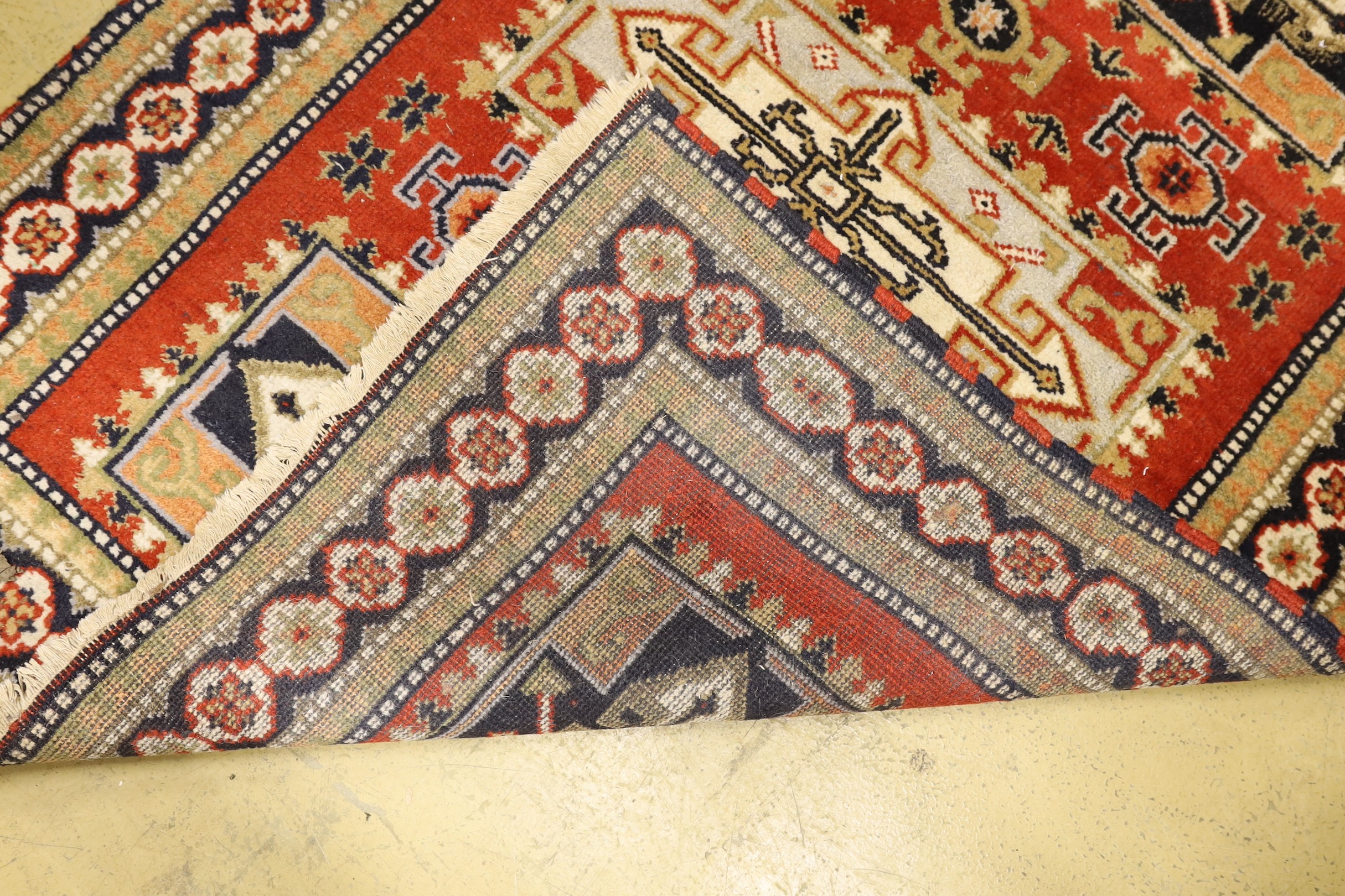 A Caucasian style brick red ground rug, 180 x 128cm